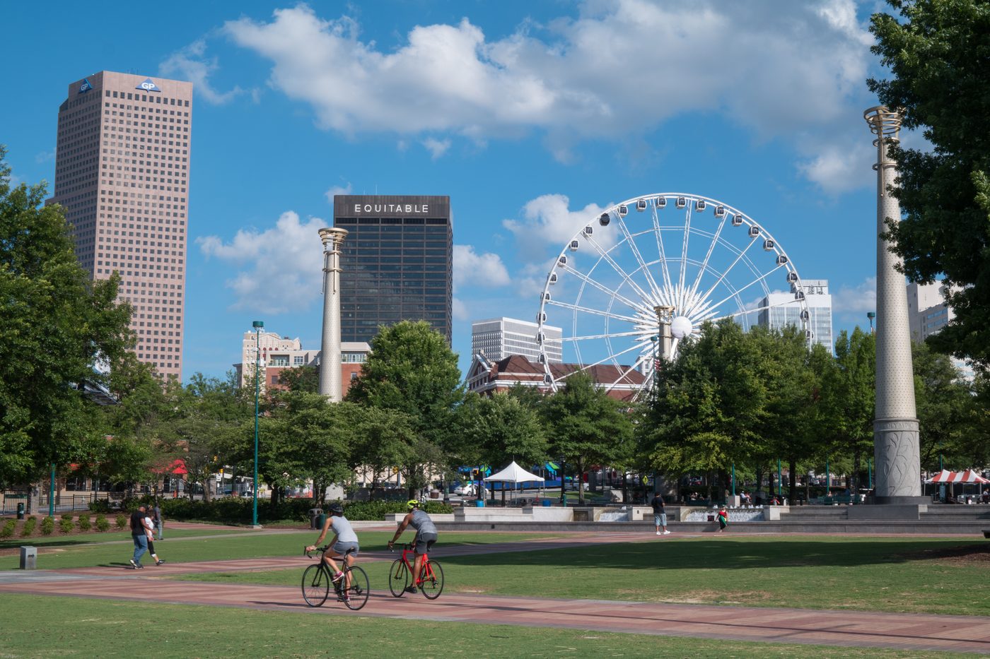Cyclists in Centennial Olympic Park with the downtown Atlanta skyline behind